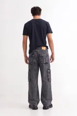Pantalón tipo jean de corte baggy con diseño cargo, presenta bolsillos laterales amplios con solapa y costuras reforzadas. Confeccionado en denim de algodón con acabado lavado.