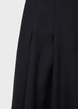 Falda larga de corte evasé en color negro, confeccionada en tejido fluido con detalle de pinzas y bolsillos laterales. Cuenta con cierre de cremallera y gancho.