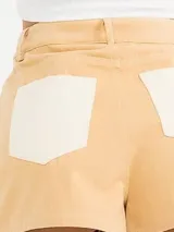 Short de gabardina color beige con detalles de costuras y paneles laterales en color tostado, diseño de tiro medio con cierre frontal y bolsillos laterales.