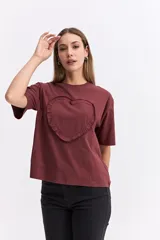 Remera de corte oversize color bordó, con cuello redondo y manga corta. Presenta un aplique frontal en forma de corazón con detalle de volados en el contorno.