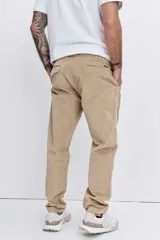 Pantalon de corte recto confeccionado en pana color beige, con cintura elástica y cordón ajustable.