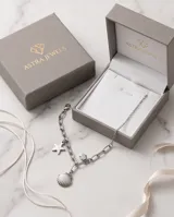 Collar de cadena de eslabones de acero con dijes colgantes: una estrella, una concha marina y una pequeña circonia.