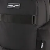 Mochila Puma Deck negra con logo blanco estampado. Tiene dos correas frontales ajustables con hebilla, un bolsillo lateral con logo Puma y un compartimento principal con cierre.