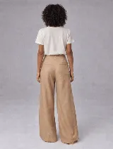 Pantalón de tiro alto con corte relajado y pierna ancha. Confeccionado en lino, presenta pretina con presillas, cierre frontal con botón y tablas delanteras que aportan estructura.