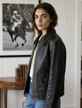 Chaqueta de cuero vacuno con acabado envejecido, diseño de cuello camisero, cierre frontal con botones metálicos y bolsillos frontales con solapa.