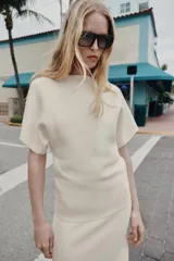 Jersey de punto liso con cuello redondo y manga corta con sisa ancha, de corte holgado.