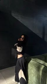 Conjunto deportivo unisex compuesto por un hoodie corto con capucha y un pantalón estilo baggy. Ambas prendas presentan un diseño bicolor en negro y beige con paneles laterales contrastantes.