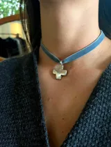 Gargantilla tipo choker de cinta de terciopelo color azul con dije de cruz metálica en acabado plateado.