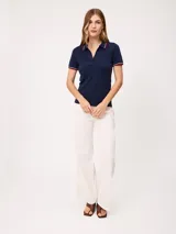 Remera polo azul marino de manga corta, con cuello en V sin botones y ribetes tricolores en el cuello y los puños.