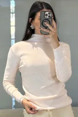 Buzo de tejido de punto fino en color verde, con cuello medio y mangas largas, de corte ajustado al cuerpo.