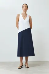 Maxi vestido bicolor, blanco en la parte superior y azul marino en la falda, sin mangas y con escote en V.