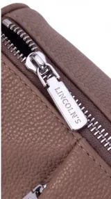 Bandolera de cuero sintético negro con diseño estructurado, múltiples bolsillos con cierre, correa ancha ajustable y herrajes metálicos plateados.