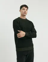 Sweater de punto con cuello redondo, manga larga y puños y ruedo acanalados. Presenta un diseño jaspeado en tonos oscuros.