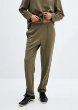 Pantalon de corte recto y tiro alto confeccionado en tejido de piqué color verde militar. Presenta cintura elástica, bolsillos laterales y costuras decorativas frontales que simulan una tabla.