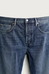 Jeans regular fit de corte recto confeccionados en denim de algodón, con efecto lavado, cinco bolsillos y cierre frontal con cremallera y botón.