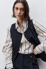 Short de tiro alto confeccionado en algodón, con calce relajado y silueta recta. Presenta pinzas delanteras, bolsillos laterales y botones decorativos en la cintura.
