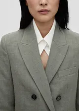 Blazer de corte recto y diseño cruzado, confeccionado en tejido mezcla de lana. Presenta cuello con solapas de muesca, cierre frontal con botones, bolsillo de ribete en el pecho y dos bolsillos laterales con solapa.
