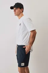 Short de baño de color azul marino, con cintura elástica y cordón ajustable blanco, bolsillos laterales y parche distintivo en el bajo. Presenta una textura con sutil efecto arrugado.