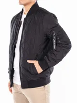 Campera bomber negra Calvin Klein con diseño acolchado en forma de rombos, cierre frontal con cremallera, cuello, puños y dobladillo acanalados, bolsillos laterales y bolsillo con cremallera en la manga izquierda.