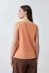 Musculosa de calce holgado en color durazno, con estampado paisley en relieve (puff print) en tonos rojizos. Presenta cuello redondo y diseño sin mangas.