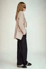 Blazer de cuello solapa y manga larga, con bolsillos delanteros con solapa y cierre frontal de un botón. Presenta un diseño estructurado con forro interior.