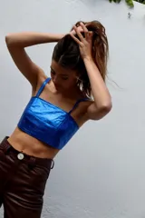 Top corto estilo corset o bandeau, color dorado metálico, con tirantes anchos ajustables.