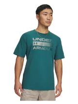 Remera de manga corta Under Armour color verde petróleo, con estampado frontal del logo y nombre de la marca en tono metalizado sobre una franja horizontal. Confeccionada en tejido Charged Cotton de secado rápido y elástico.