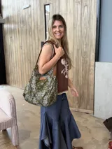 Bolso tipo hobo de tamaño mediano con diseño paisley en color verde militar y blanco, con asas de cuero marrón y etiqueta frontal de la marca.