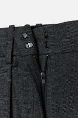 Pantalón de tiro medio con diseño de pierna ancha y pinzas frontales. Cuenta con cintura con trabillas, bolsillos laterales ocultos y cierre frontal con cremallera, botón y ganchos metálicos.