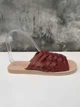 Sandalias bajas color marrón con tiras de cuero trenzadas.