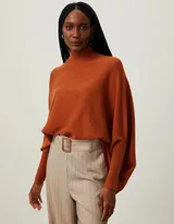 Sweater de punto color naranja, con cuello alto y mangas dolman.
