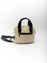 Bolso pequeño color beige con diseño acolchado, doble asa de mano negra y correa larga negra desmontable y regulable.