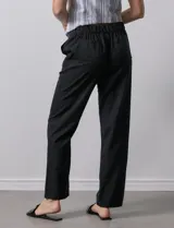 Pantalón de corte recto confeccionado en mezcla de lino, color verde claro. Presenta una pretina ancha con lazo de ajuste frontal y bolsillos laterales verticales.