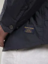 Campera casual liviana de nylon, con cierre frontal de botones a presión, cuello camisero y bolsillos frontales tipo parche.