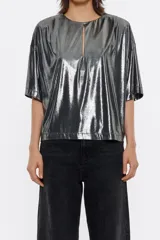 Camiseta plateada metalizada de corte recto, con escote redondo con abertura en forma de lágrima en el delantero, manga corta amplia y hombreras con pliegues.