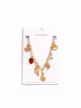 Collar de cadena de eslabones dorados con múltiples dijes colgantes que incluyen una ancla, una frutilla esmaltada en rojo, un caballito de mar, una caracola, una palmera y una perla sintética.