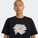 Remera negra de manga corta con cuello redondo y un estampado fotorrealista de tickets o recibos apilados en el centro del pecho.