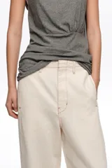 Pantalón balloon tobillero color crudo con diseño de rayas verticales oscuras, tiro medio y bolsillos delanteros. Confeccionado en mezcla de algodón y lino.