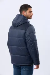 Campera puffer reversible para hombre, de color negro, con diseño capitonado, capucha integrada y bolsillos funcionales con cierre frontal.