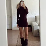 Vestido corto de manga larga en color bordó, con cuello alto y diseño ajustado con frunces laterales que recorren toda la prenda.