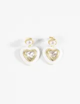 Par de caravanas doradas con clip, con forma de corazón blanco y cristal facetado en el centro.