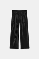 Pantalón de tiro alto color negro, confeccionado en tejido satinado con acabado brillante. Presenta cintura elástica, bolsillos frontales ocultos en costura y diseño de pierna ancha.