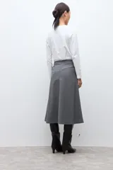 Falda midi de corte acampanado con estampado de cuadros pequeños en tonos grises. Presenta un diseño de tiro alto y estructura firme.