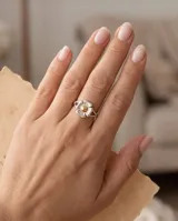Anillo de plata con diseño de flor y detalle central dorado.