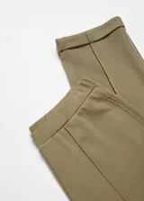 Pantalon de tiro alto confeccionado en tejido de piqué color verde militar, con cintura elástica y costuras decorativas frontales que simulan un estilo sastrero.