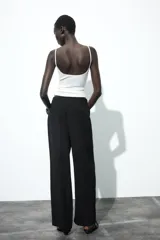 Pantalón de tiro medio color marrón, con pierna recta y detalle de superposición frontal tipo pareo.