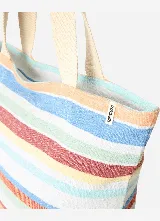 Bolso de mano tipo tote bag de Rip Curl, modelo Oceanic Interest, con diseño de rayas horizontales multicolor y asas dobles de tela color beige.