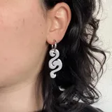 Par de aros colgantes plateados con forma tribal.