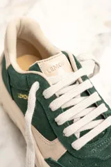 Zapatillas deportivas de gamuza verde con detalles en cuero color crema, cordones blancos y suela chunky color crema.