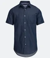 Camisa azul de manga corta con cuello clásico, corte slim fit, cierre frontal con botones blancos y bolsillo de parche en el pecho.